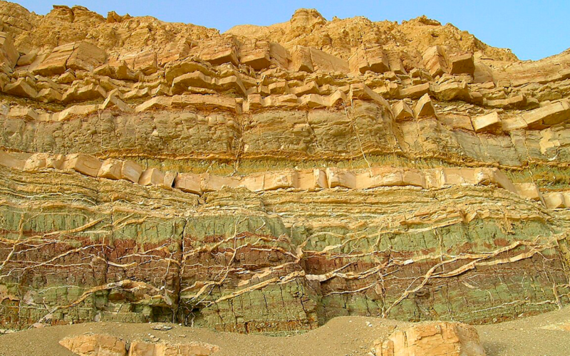 Imagem ilustrativa de uma seção transversal de uma rocha, destacando suas várias camadas e estruturas.