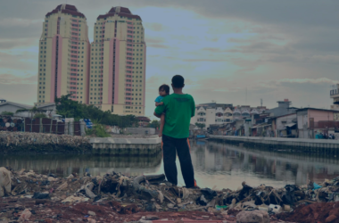 Imagem ilustrando a segregação urbana, onde há um pai com seu filho dentro de uma "favela" olhando para a grande cidade. Represetando a diferença da grande cidade com a favela.