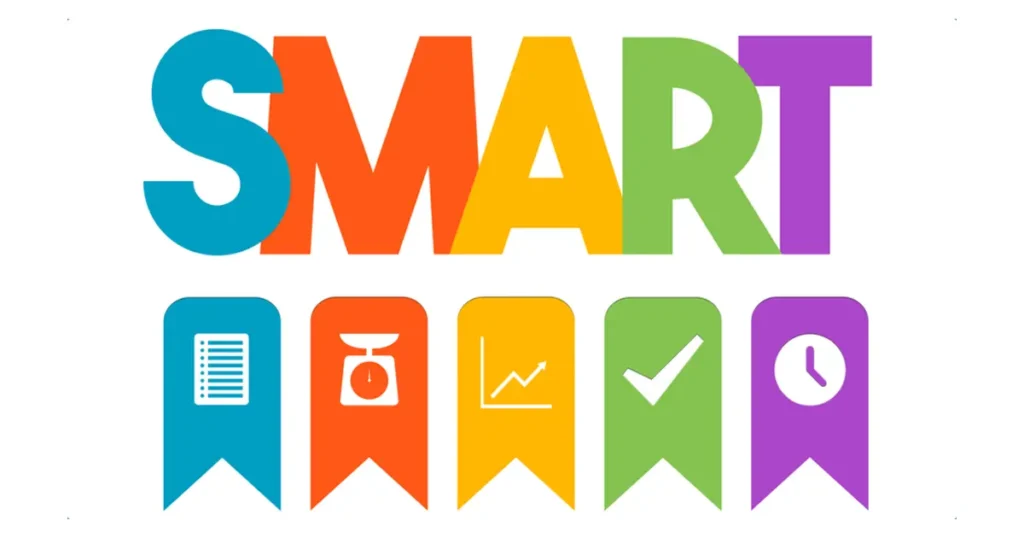 A imagem exibe a sigla colorida "SMART" remetando a metas, onde cada letra é acompanhada de um ícone que ilustra os princípios de estabelecer metas eficientes: Específicas, Mensuráveis, Alcançáveis, Relevantes e Temporais.